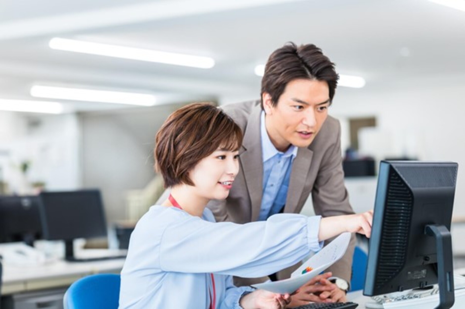 パソコンの前で確認をする男女
