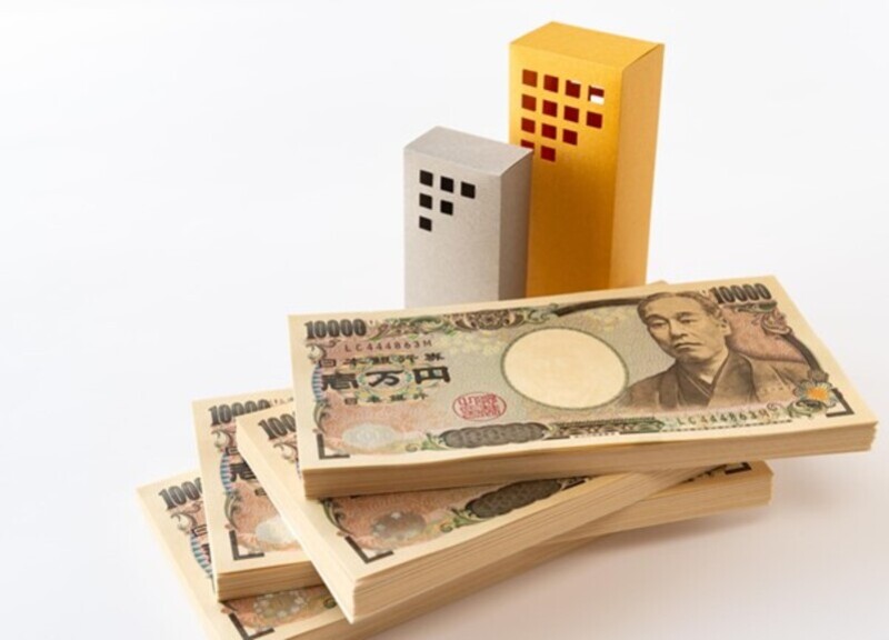 小さなビルの模型と100万円札束4束