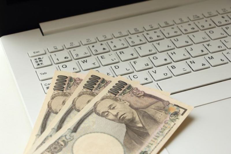 キーボード上の3枚の一万円札