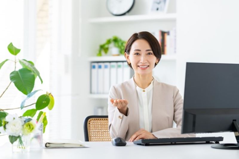 パソコンの前の笑顔の女性