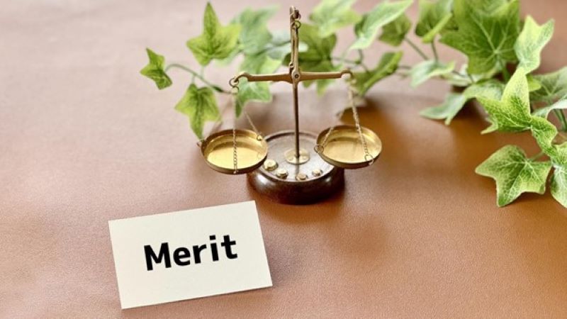 天秤と「Merit」と書かれたカード