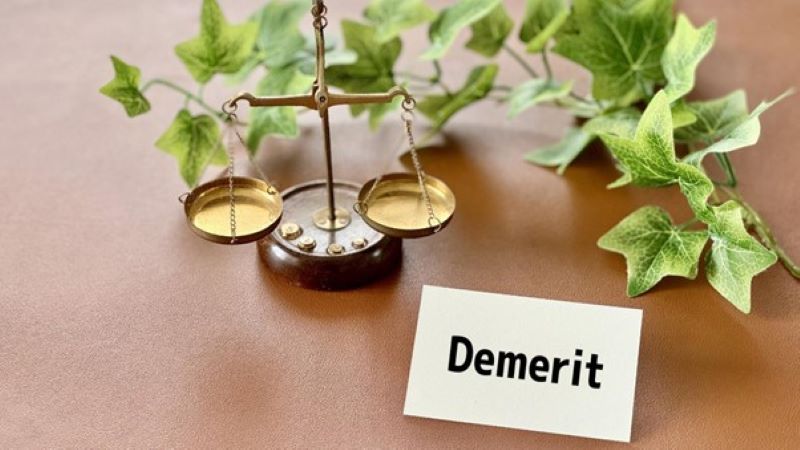 天秤と「Demerit」と書かれたカード