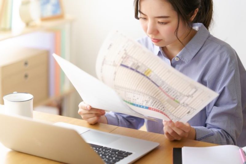 パソコンの前で資料を見ている女性