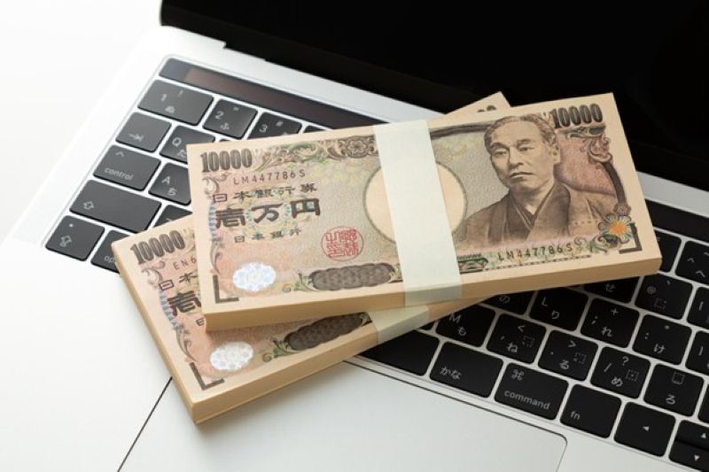 ノートパソコン上の一万円札束