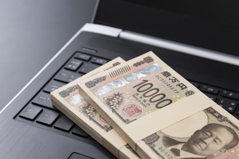 ノートパソコン上の一万円札束