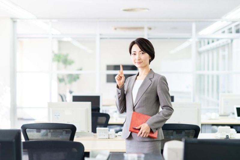 オフィスでナンバーワンポーズをする女性