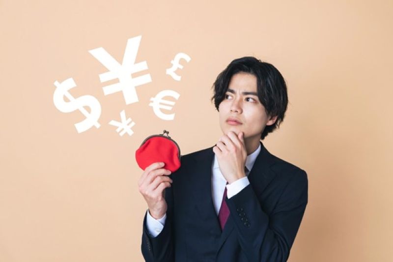 財布を持ち考え込む男性